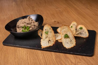 Bir tabak sığır ciğeri ve siyah tabakta sebzeli et ve çıtır tost. Restoran yemekleri.
