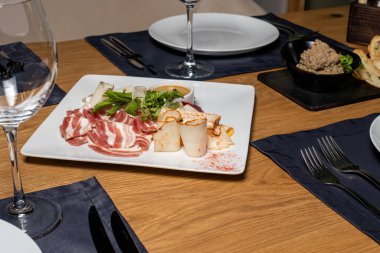 Yağ, domuz yağı ve pastırmayı servis edilmiş ahşap bir masada beyaz bir tabakta dilimliyorum. Domuz eti, et.