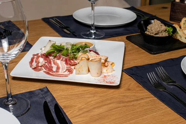 Yağ, domuz yağı ve pastırmayı servis edilmiş ahşap bir masada beyaz bir tabakta dilimliyorum. Domuz eti, et.