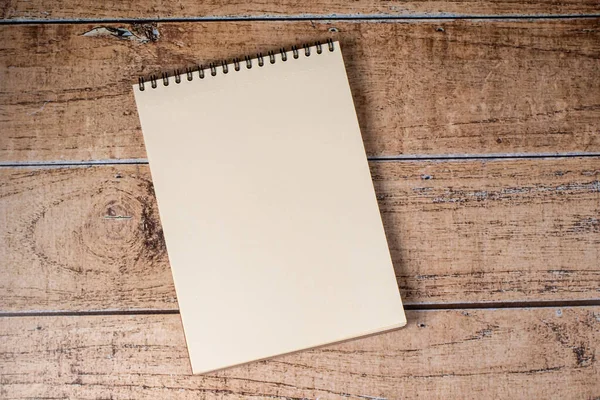 White sheet page notepad on a wooden brown background. A pad on a spiral, a place for notes
