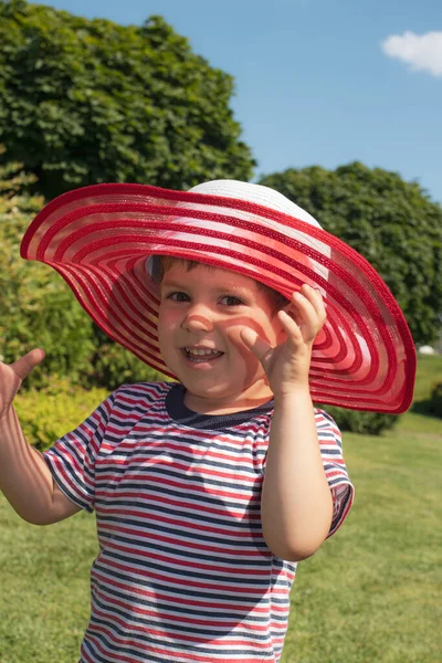 Un niño de 3 años con sombrero rojo y camiseta a rayas. Feliz infancia en el verano. Protección solar para niños — Foto de Stock