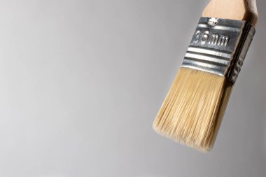 Duvarları ve nesneleri boyamak için kullanılan gri bir arka planda boya fırçası. Onarım için araçlar