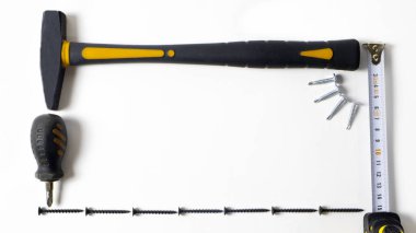 Metin için alanı olan beyaz bir arkaplanda inşaat araçları. Çekiç, makas ve rulet aletleri evde tamir edilecek. İnşa araçları.