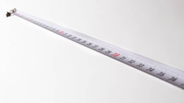 Beyaz arkaplandaki sayıları santimetre olan şerit. Yapı araçları.