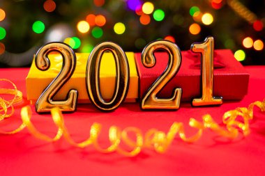 İçinde 2021 haneli güzel bir noel kartı ve arkasında kırmızı bir arka planda altın bir kurdele var. Yeni yıl, şenlik havası, boğa yılı.