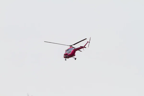 Czerwony helikopter leci po niebie. Podróże lotnicze, lot. — Zdjęcie stockowe