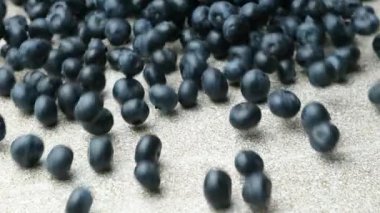 Taze olgun yaban mersinleri masada yuvarlanıyor, böğürtlen sıçraması, yavaş çekim makrosu