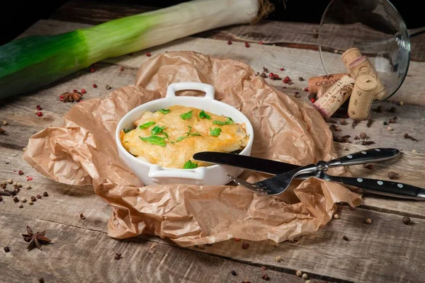 Chicken julienne served on craft paper with leeks. On a beautiful wooden background — Stock Image Chicken julienne served on craft paper with leeks. On a beautiful wooden background Royalty Free Stock Photos