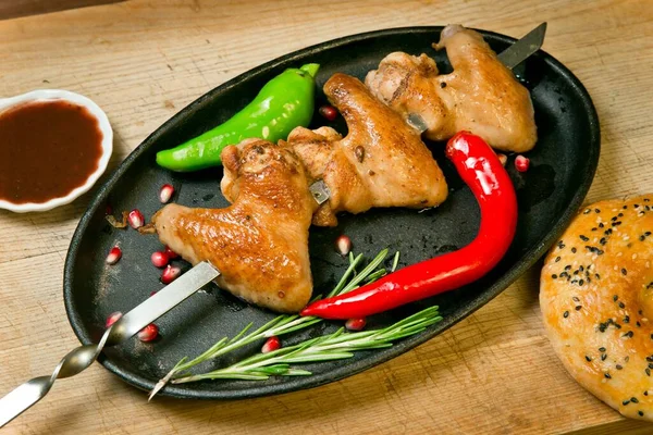 Izgara tavuk kanadı ve acı biber. Barbekü sosu ve taze tortilla ile. Tahta tepside