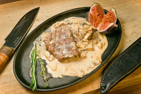 Biftek, kızarmış patates ve taze incir. Barbekü sosu ve taze tortilla ile. Tahta tepside
