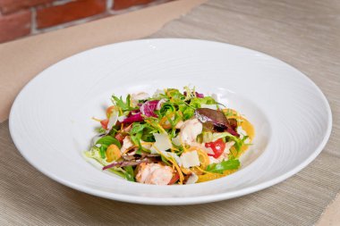 Lezzetli Sezar salatası, karides ve parmesan peyniri. Beyaz bir tabakta.