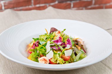 Lezzetli Sezar salatası, karides ve parmesan peyniri. Beyaz bir tabakta. yakın çekim görünümü