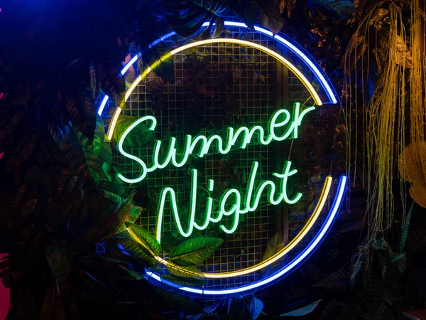 Siyah zıt bir arkaplanda yeşil neon ışığı. Bitkilerin yeşil yaprakları