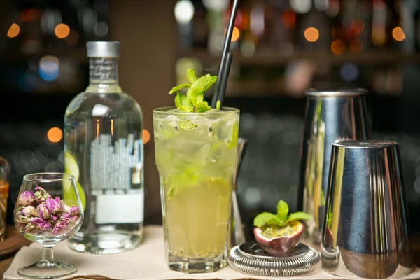 Tahta tepside incir ve güllerle mojito kokteyli. Bir restoran barının arka planında