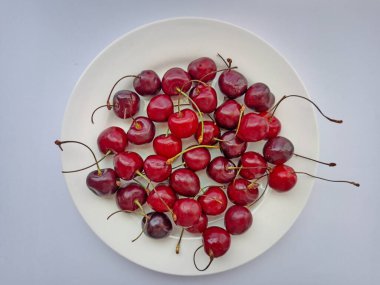  Arka planda taze kirazlar. Olgun kırmızı böğürtlenler. Seçici odak