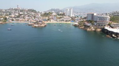Büyüleyici bir insansız hava aracı Acapulco 'daki ikonik Caleta Sahili' ne yaklaşıyor, davetkar kıyılarını ve canlı atmosferini gösteriyor.