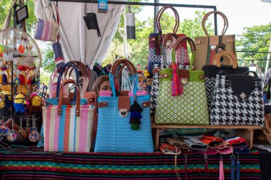 Guadalajara, Meksika - 10 Ağustos 2025: Canlı el yapımı çantalar ve aksesuarlar Zapopan sokak pazarındaki yerel bir el sanatları tezgahında sergilendi