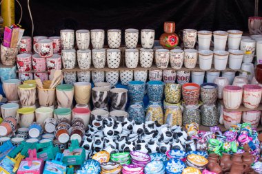 Cocula, Meksika - 27 Nisan 2025: Cocula, Meksika 'da yerel bir sokak pazarında el yapımı seramik bardaklar ve renkli çömlekler satılıyor