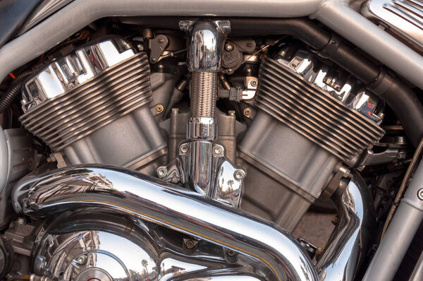 Фрагмент двухцилиндрового мотоцикла с хромированными деталями
