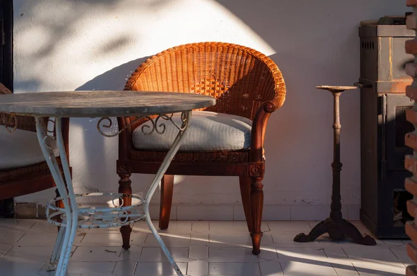Ein Korbstuhl Ein Tisch Mit Metallbeinen Und Einer Hölzernen Tischplatte — Stockfoto