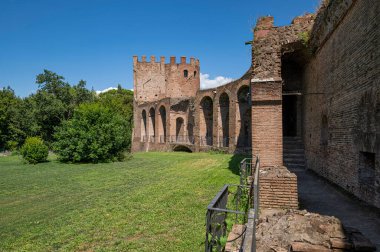 Porta San Sebastiano 'daki Aurelian Roma Duvarları şehrin içinden görüldü. Tuğla destekli kemerler ve kaldırım kaldırımı. Duvarlar ağaçlarla çevrili geniş bir çimenlik. Bulutlarla dolu açık bir gün. İtalya