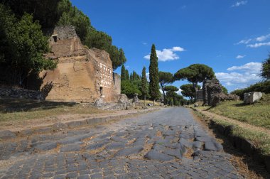 Güneşli bir günde Via Appia 'daki tuğla mezar fotoğrafı çekildi. Roma İmparatorluğu 'nun en önemli yollarından biriydi. Antik asfalt kalıntıları, diğer anıtlar, deniz çam ağaçları..