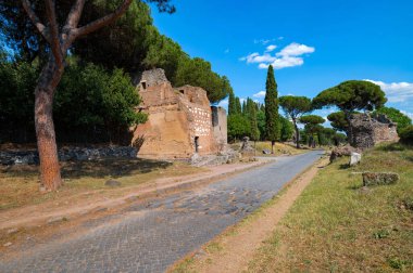 Brick tomb on the Via Appia photographed on a sunny day. It was one of the most important roads of the Roman Empire, remains of the ancient paving, of other tombs, maritime pines, cobblestone. clipart