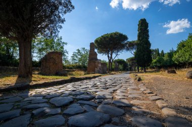 Roma medeniyetinin en önemli konsolosluk yollarından biri olan Appia Antica 'nın kaldırım manzarası. Tuğla mezarın yanında bu yol Roma 'yı Brindisi' ye bağladı. İtalya.