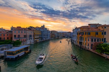 Accademia Köprüsü 'nden ya da Ponte dell' Accademia 'dan görülen Kanal Grande ve saraylarının harika bir akşam fotoğrafı. Gün batımında suya yansıyan turuncu ve mavi bulutlar. Venedik, İtalya