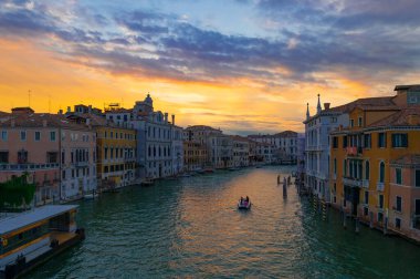 Accademia Köprüsü 'nden ya da Ponte dell' Accademia 'dan görülen Kanal Grande ve saraylarının harika bir akşam fotoğrafı. Gün batımında suya yansıyan turuncu ve mavi bulutlar. Venedik, İtalya.
