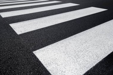 Özellikle yaya geçidi, asfalt yol, koyu gri arka planda beyaz çizgiler, zebra çizgileri, perspektif manzarası, siyah ve beyaz.