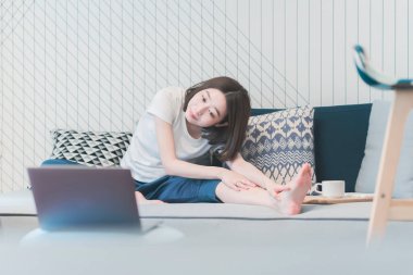 Genç Asyalı kadın oturma odasında yoga dersi alıyor.