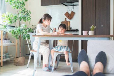 Anne ve kızı evdeki yemek masasında resim çiziyorlar.