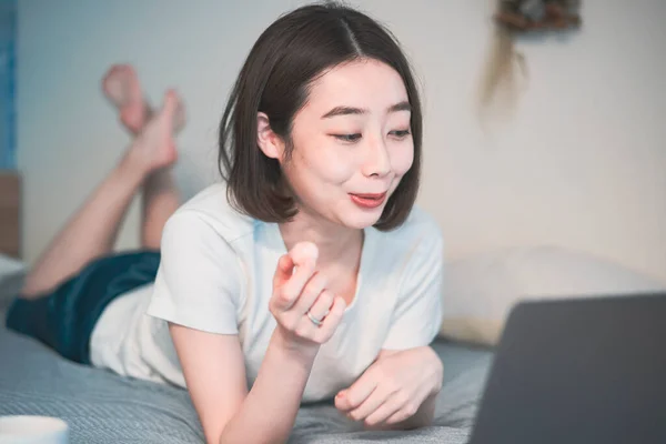 Asian young woman looking at laptop screen in the room at home
