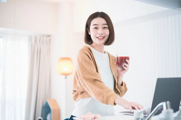 アジアの若い女性は自宅でラップトップでリモートで作業 — ストック写真