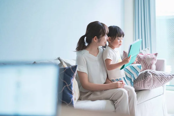 Mutter Und Tochter Sitzen Auf Dem Sofa Und Lesen Ein — Stockfoto