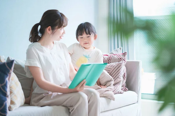 Mutter Und Tochter Sitzen Auf Dem Sofa Und Lesen Ein — Stockfoto