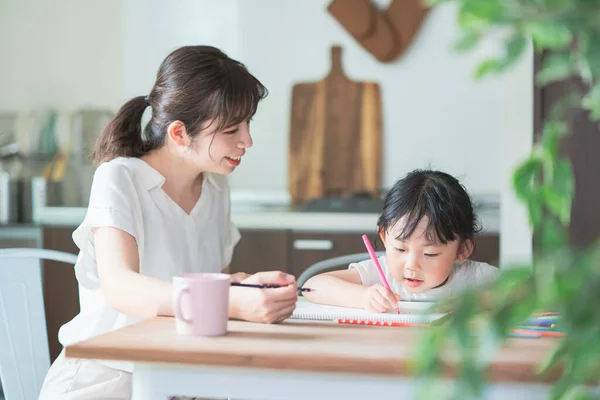 家のダイニングテーブルで母と娘の絵 — ストック写真