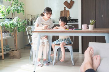 Anne ve kızı evdeki yemek masasında resim çiziyorlar.