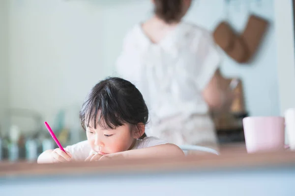 Азиатская Девушка Рисует Красочными Ручками Обеденным Столом Дома — стоковое фото