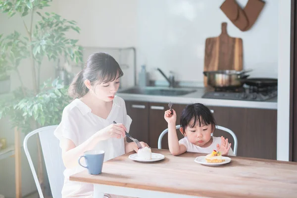 亚洲妈妈和女儿在家里的饭桌上吃蛋糕 — 图库照片