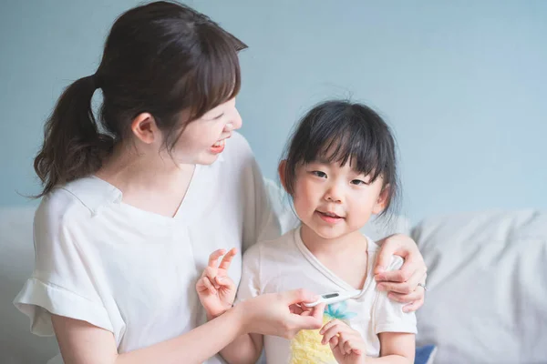 Ein Asiatisches Mädchen Bekommt Ihre Mutter Ihre Körpertemperatur Messen — Stockfoto