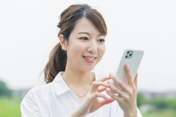 Asiatische Junge Frau Bedient Während Sie Auf Smartphone Bildschirm Schaut — Stockfoto