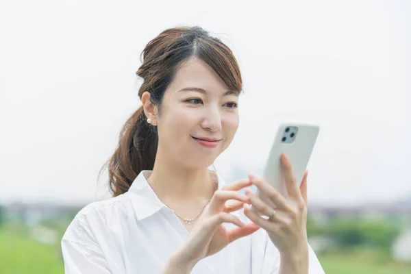 Asiatisk Ung Kvinna Som Arbetar Medan Tittar Smartphone Skärmen — Stockfoto