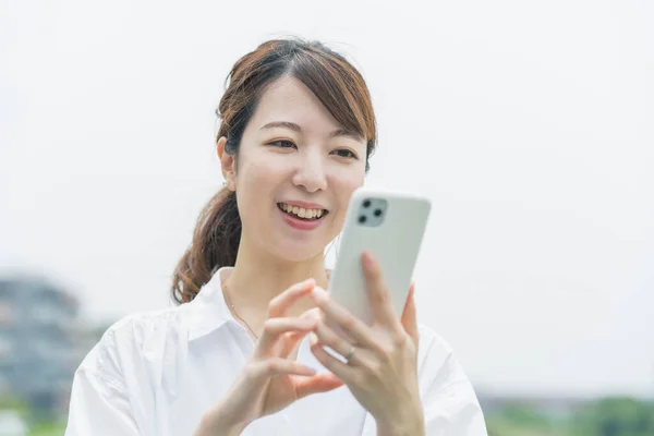 Asiatische Junge Frau Bedient Während Sie Auf Smartphone Bildschirm Schaut — Stockfoto