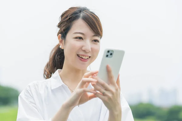 Asiatisk Ung Kvinna Som Arbetar Medan Tittar Smartphone Skärmen — Stockfoto