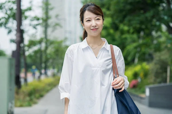 Beyaz Gömlekli Asyalı Genç Kadını Alışveriş Çantasıyla Dışarı Çıkıyor — Stok fotoğraf