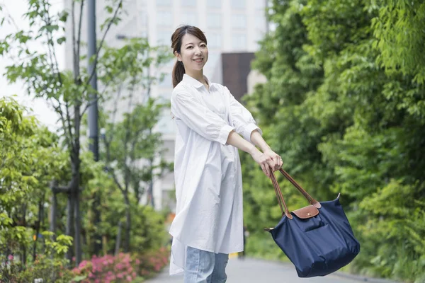 Beyaz Gömlekli Asyalı Genç Kadını Alışveriş Çantasıyla Dışarı Çıkıyor — Stok fotoğraf