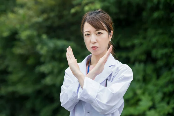 身穿白衣 摆出拒绝 错误姿态的亚洲女性医护人员 — 图库照片