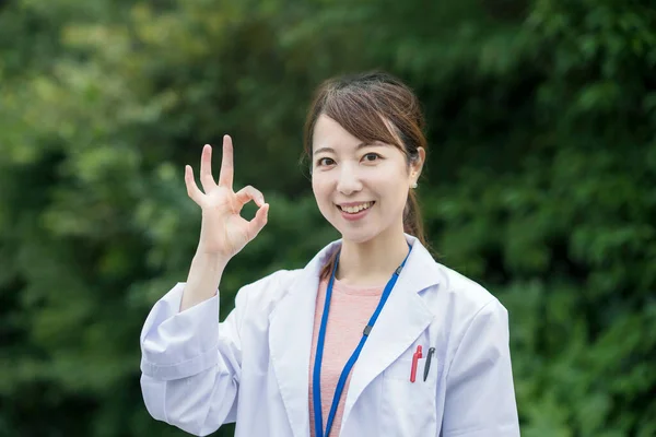 Beyaz Önlüklü Dışarıda Poz Veren Asyalı Kadın Sağlık Görevlisi — Stok fotoğraf